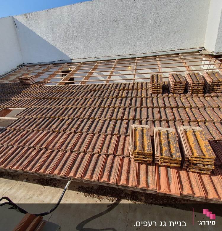 רעפים מונחים על גג בתהליך בנייה